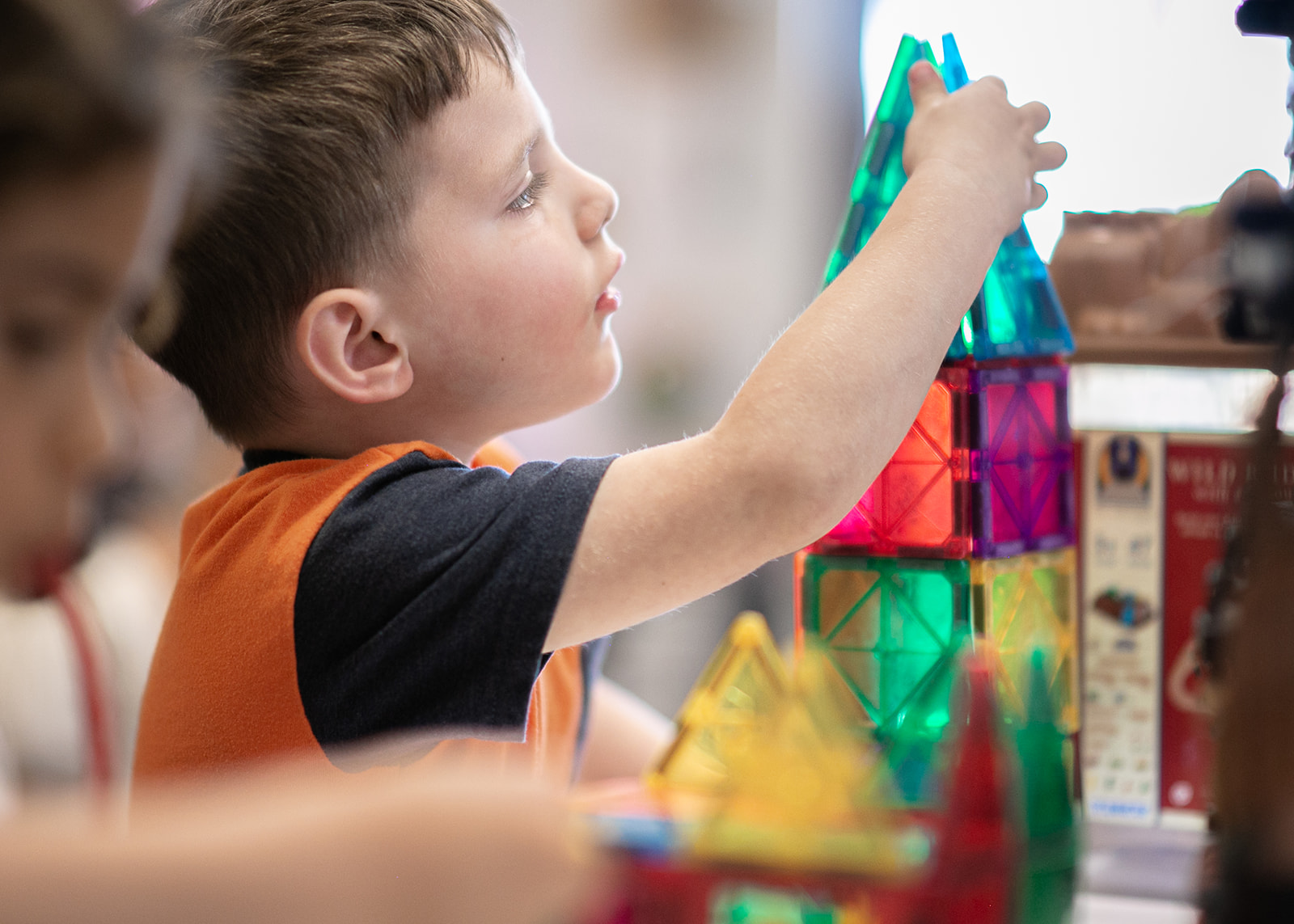 Child building with colorful magnetic tiles